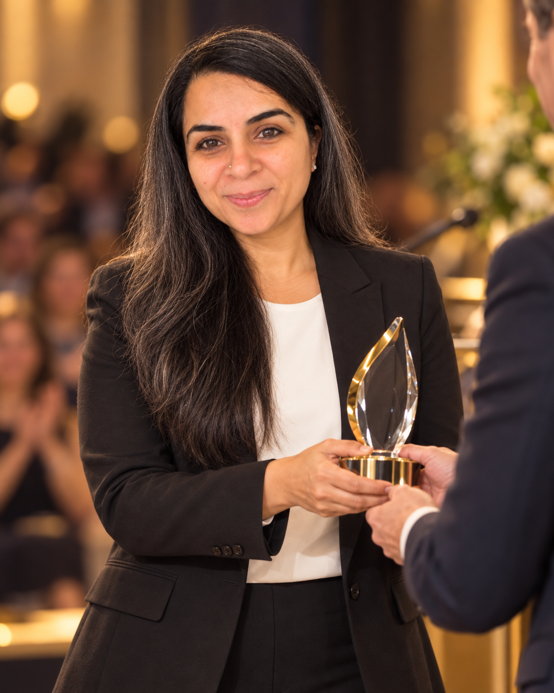 Sonal receiving an unbranded recognition trophy at a professional event